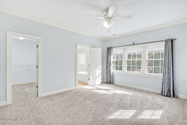 unfurnished bedroom featuring light carpet, connected bathroom, a spacious closet, and ornamental molding