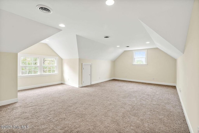 bonus room featuring vaulted ceiling and light carpet