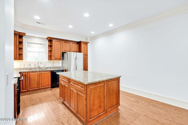 kitchen featuring a kitchen island, black dishwasher, stainless steel fridge, light hardwood / wood-style floors, and light stone countertops