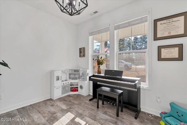 misc room with hardwood / wood-style flooring and a notable chandelier