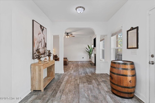 corridor with hardwood / wood-style floors and ornate columns