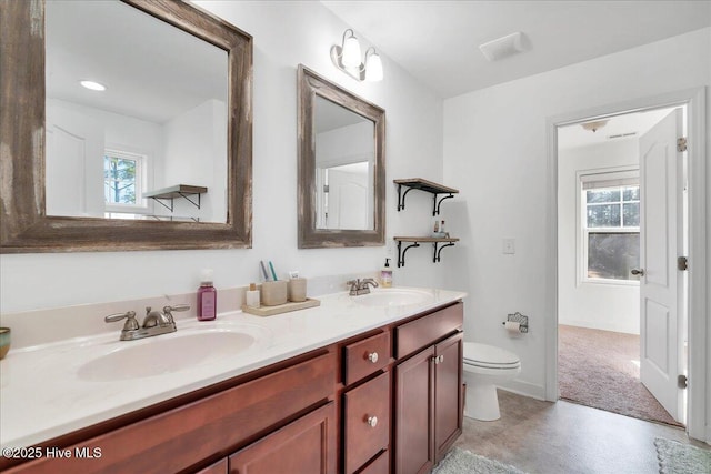 bathroom featuring plenty of natural light, toilet, and vanity