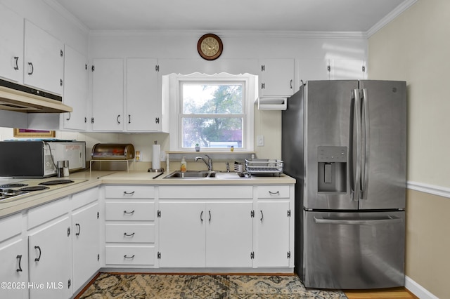 kitchen featuring white cabinets, crown molding, sink, and stainless steel fridge