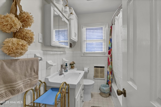 bathroom with vanity, toilet, heating unit, and tile walls