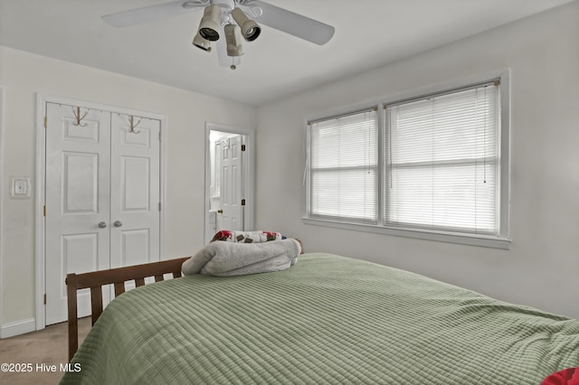 carpeted bedroom with ceiling fan and a closet