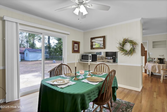 dining room featuring light hardwood / wood-style flooring, ornamental molding, and ceiling fan