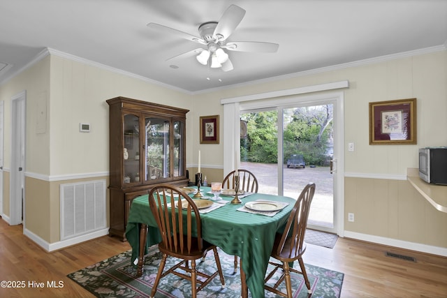 dining space featuring ornamental molding, ceiling fan, and light hardwood / wood-style flooring