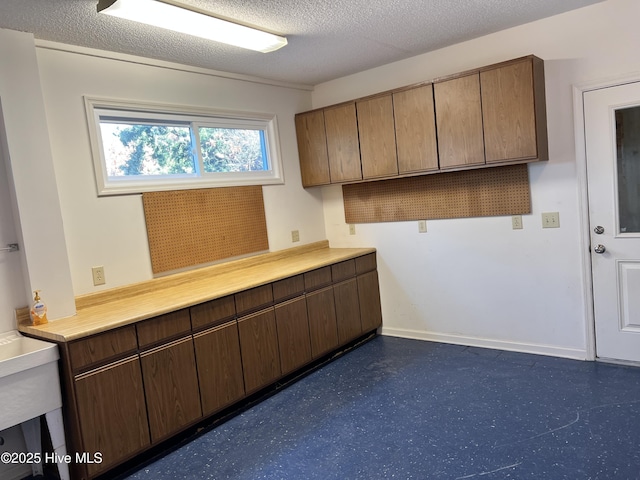 kitchen featuring dark brown cabinetry and a textured ceiling