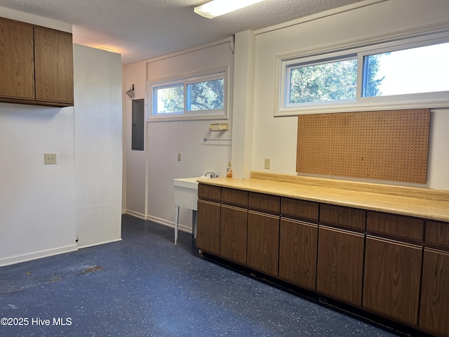 interior space featuring electric panel and a textured ceiling