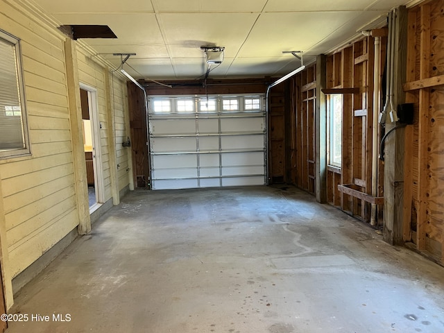 garage featuring a garage door opener and wooden walls