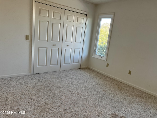 unfurnished bedroom featuring carpet and a closet