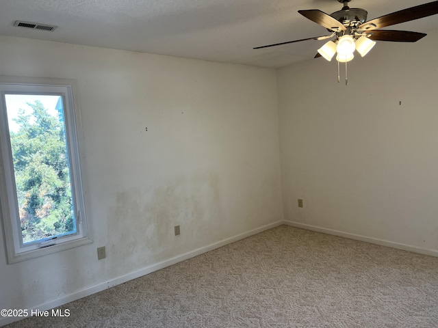 unfurnished room with ceiling fan, plenty of natural light, carpet, and a textured ceiling