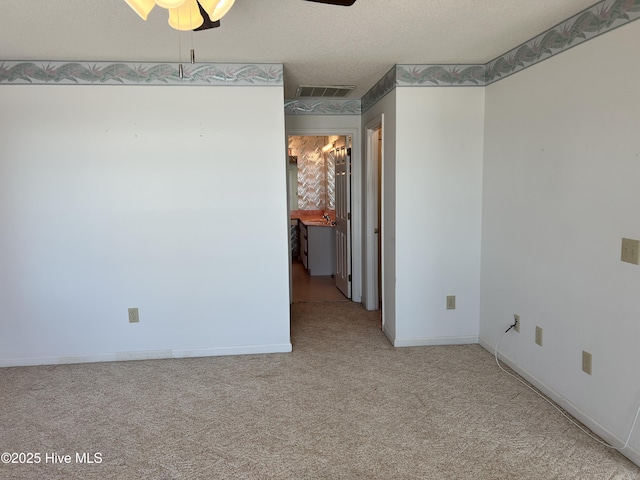 carpeted empty room with a textured ceiling and ceiling fan