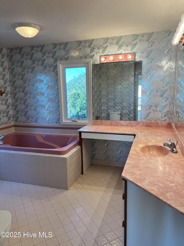 bathroom featuring tile patterned floors, vanity, toilet, and tiled tub