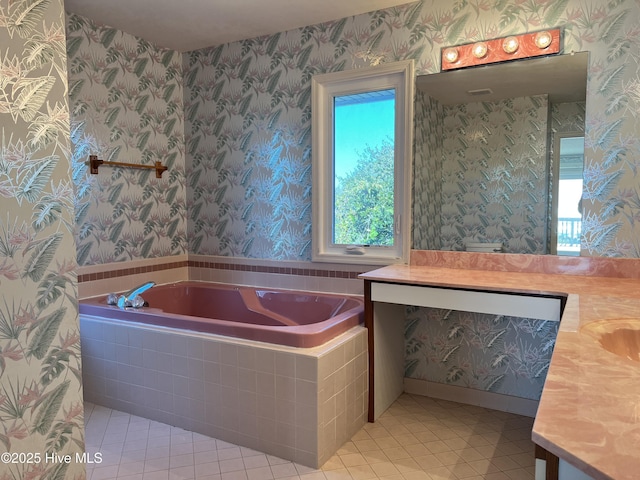 bathroom with a healthy amount of sunlight, vanity, tiled bath, and tile patterned flooring