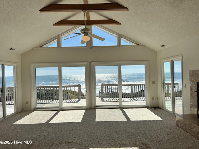 unfurnished sunroom with a wealth of natural light, vaulted ceiling, and a water view