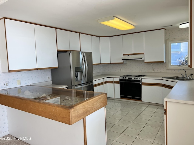 kitchen featuring sink, white cabinets, range, light tile patterned floors, and stainless steel fridge with ice dispenser