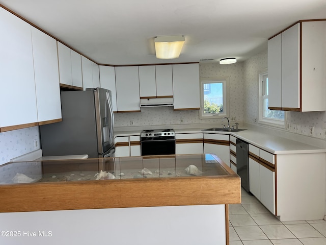 kitchen with white cabinetry, appliances with stainless steel finishes, sink, and light tile patterned floors