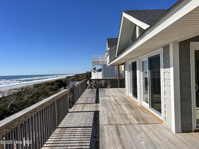 wooden deck featuring a view of the beach and a water view