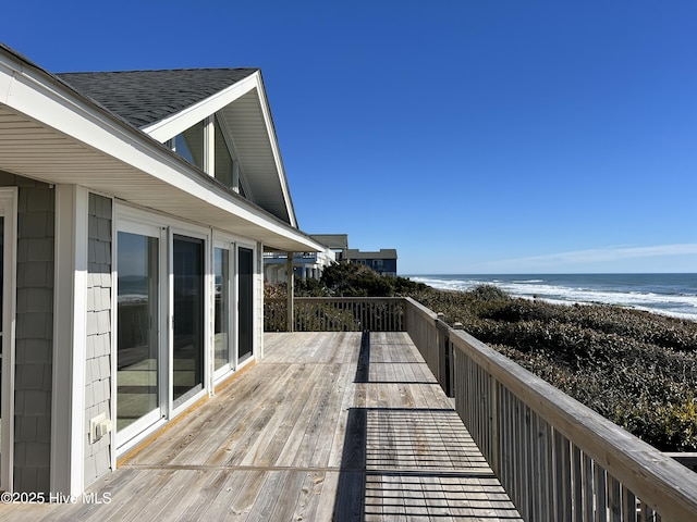 wooden deck with a beach view and a water view