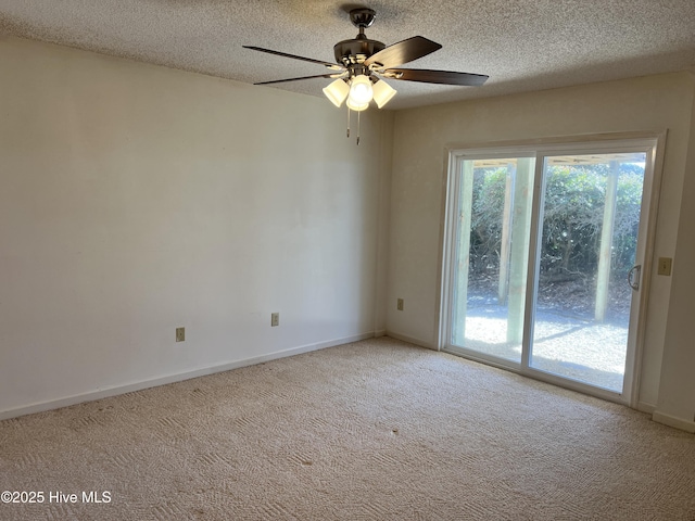 spare room with ceiling fan, light carpet, and a textured ceiling