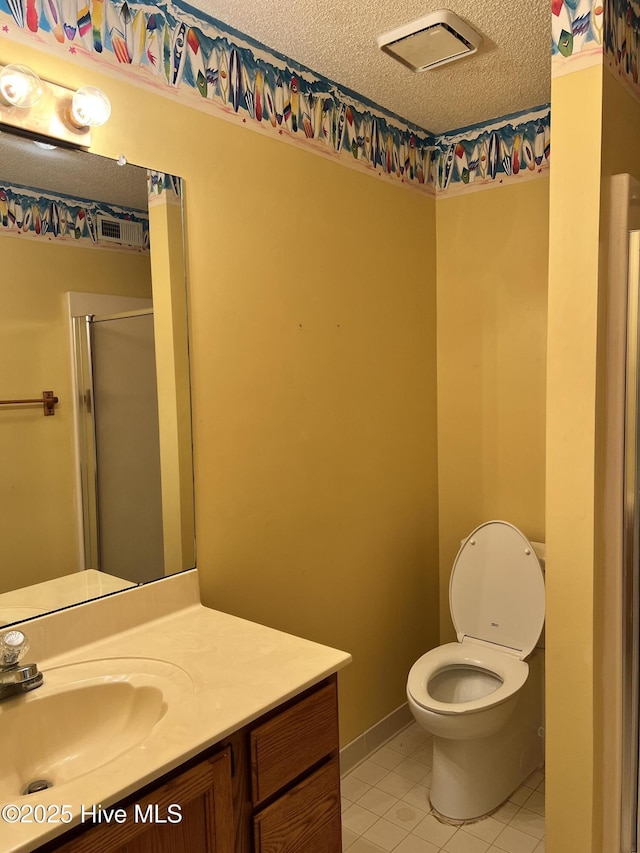 bathroom featuring vanity, an enclosed shower, a textured ceiling, and toilet