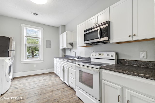 kitchen featuring a sink, visible vents, electric stove, washer / clothes dryer, and stainless steel microwave