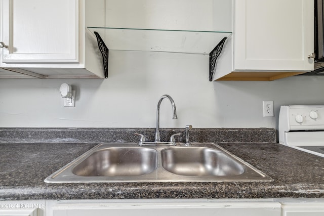 details with white range with electric cooktop, a sink, and white cabinets