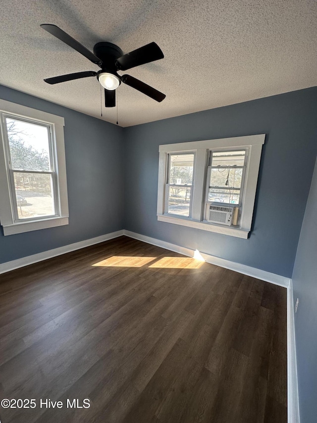 unfurnished room with wood finished floors, a wealth of natural light, and baseboards