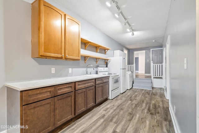 kitchen featuring open shelves, white appliances, light wood finished floors, and a sink