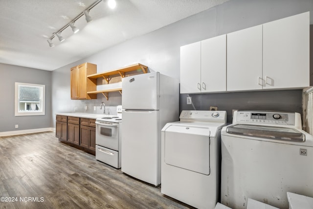 laundry area with laundry area, wood finished floors, baseboards, independent washer and dryer, and track lighting