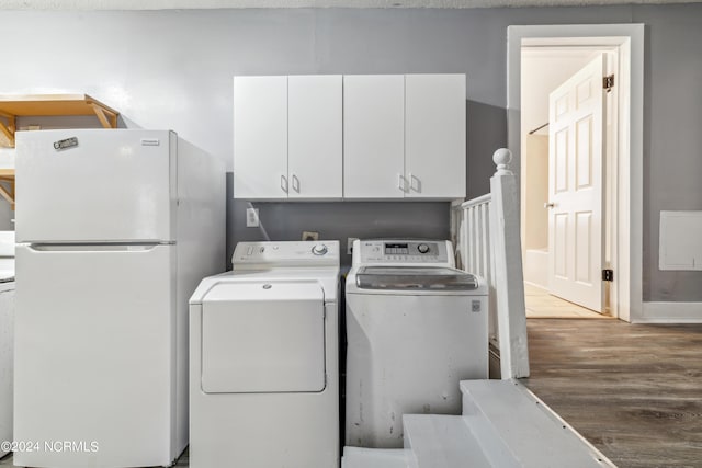 washroom featuring wood finished floors, cabinet space, and washer and dryer