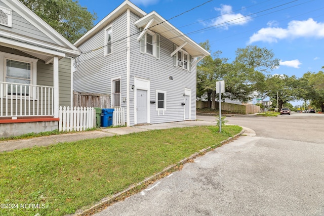 view of side of property featuring fence and a lawn