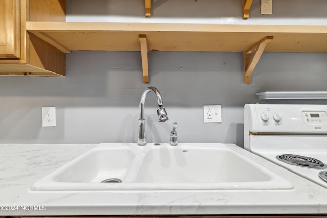 details with a sink and white range with electric cooktop