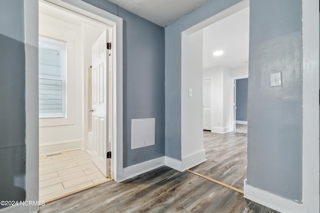 hallway with baseboards and wood finished floors