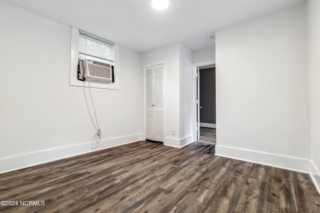 unfurnished room featuring cooling unit, dark wood finished floors, and baseboards