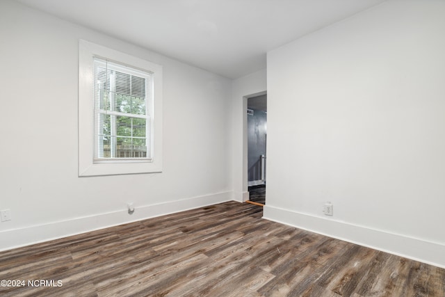 empty room featuring dark wood-type flooring and baseboards