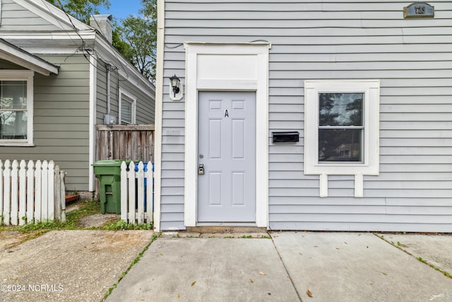 view of exterior entry featuring fence