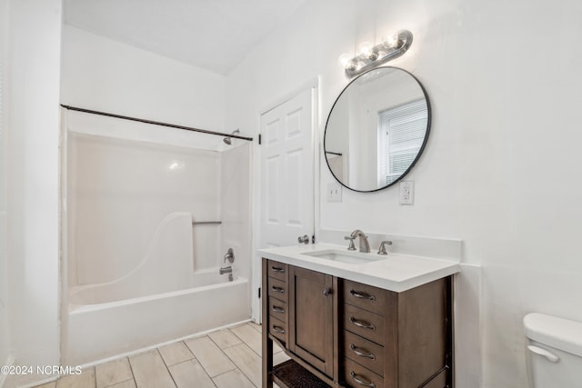 bathroom with toilet, wood tiled floor,  shower combination, and vanity