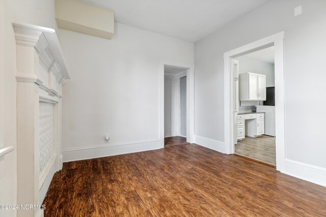 unfurnished living room with dark wood-style floors and baseboards