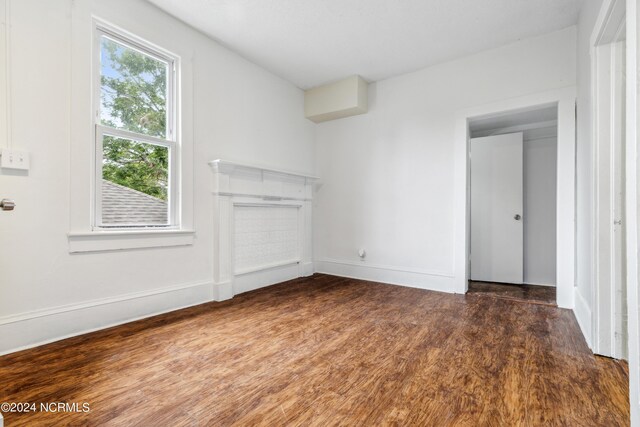 unfurnished living room with baseboards and wood finished floors