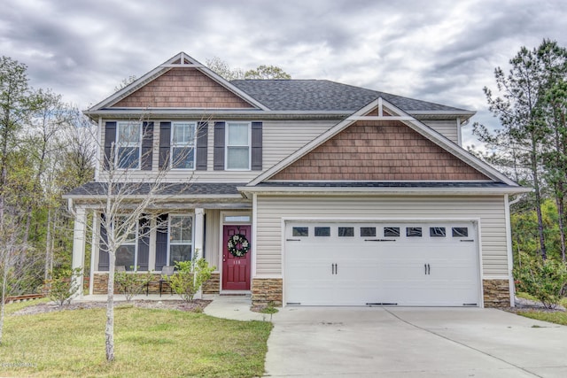 craftsman house featuring concrete driveway, roof with shingles, stone siding, and a front yard