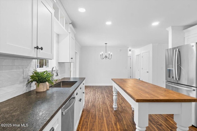 kitchen featuring white cabinetry, sink, pendant lighting, and appliances with stainless steel finishes