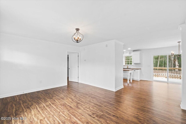 unfurnished living room featuring dark hardwood / wood-style floors and a notable chandelier