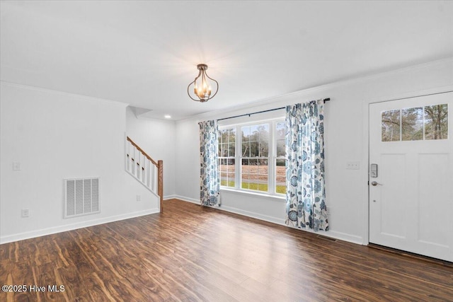 entryway featuring ornamental molding, dark hardwood / wood-style flooring, and a notable chandelier