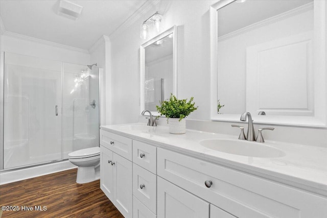 bathroom with a shower with door, crown molding, hardwood / wood-style floors, and toilet