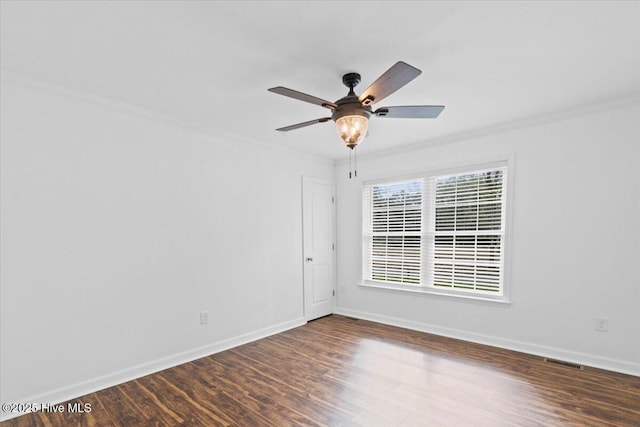 spare room with crown molding, dark wood-type flooring, and ceiling fan