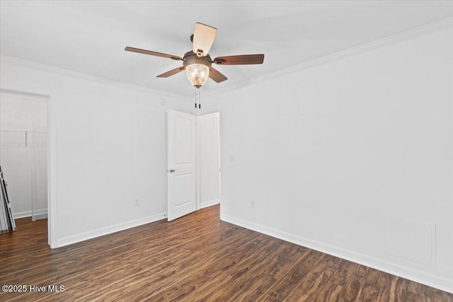 empty room featuring ceiling fan, ornamental molding, and dark hardwood / wood-style flooring