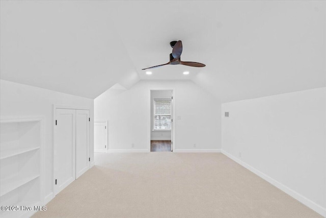 bonus room featuring lofted ceiling, light carpet, and ceiling fan