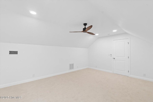 additional living space with vaulted ceiling, light colored carpet, and ceiling fan